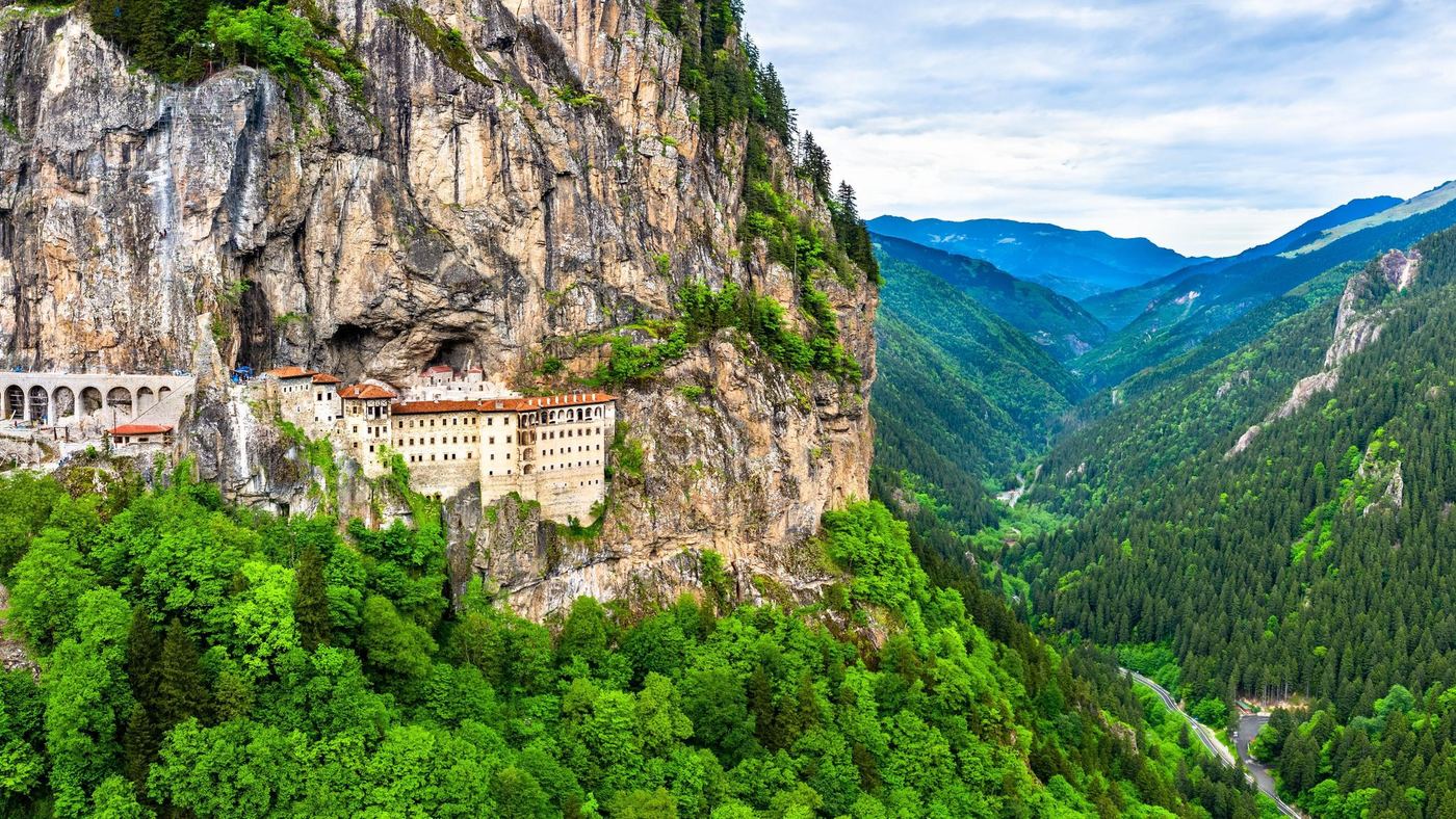 Sümela Monastery built into a sheer cliff face above a forested valley
